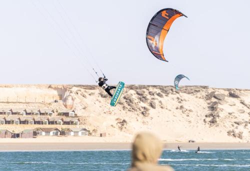 a group of people flying kites on the beach at Desert Sands Dakhla Lagoon View & Kitesurf Spot in Dakhla