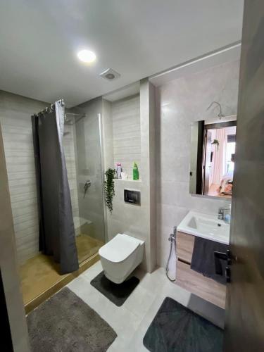 a bathroom with a toilet and a sink and a shower at Appartement à louer in Nouaceur
