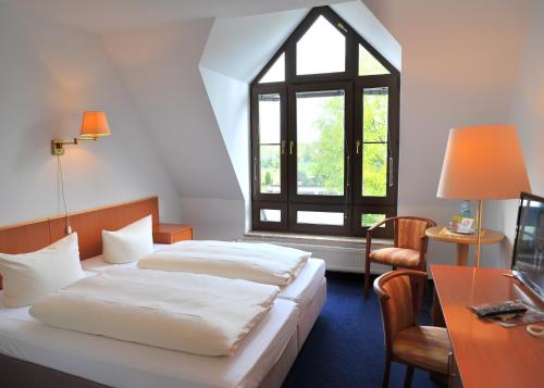 リュベナウにあるHotel Spreewaldeckのベッドが2つと窓があるホテルの部屋