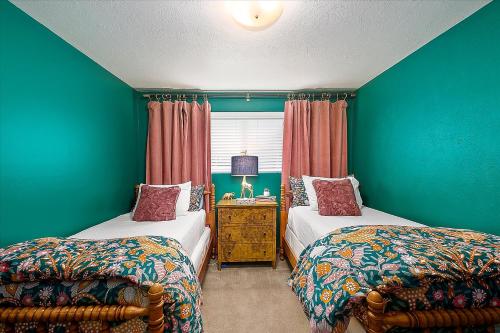 two beds in a room with green walls at The East End Retreat in Boise