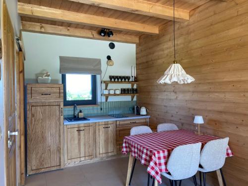 ゾンプにあるAkor House domki w Zębieのキッチン(テーブル、赤と白のテーブルクロス付)