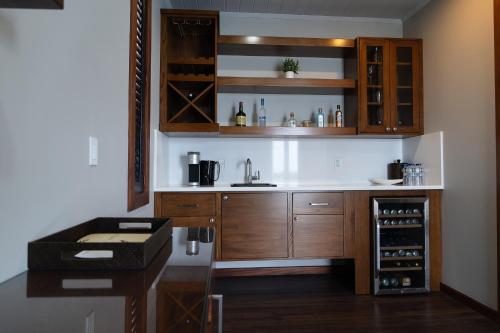 a kitchen with a sink and a counter with wine bottles at Hammock Cove Antigua - All Inclusive - Adults Only in Willikies