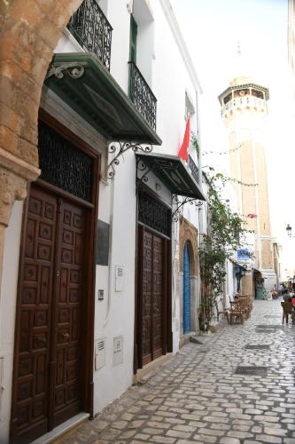 a building with brown doors on a street at Dar Hamouda Guest House - Médina de Tunis in Tunis