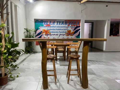 a wooden table with stools in a room at Hotel La Terrazza in Ríohacha