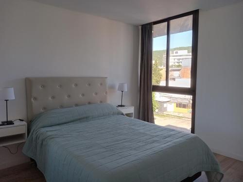 une chambre avec un lit et une grande fenêtre dans l'établissement Sam Lake 3, à Villa Carlos Paz