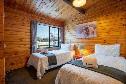 a bedroom with two beds in a log cabin at Gemini - 2BR Near Church Trails Stargazing in Lake Tekapo