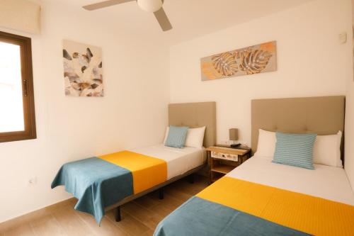 two beds sitting next to each other in a room at Oasis Dunas Corralejo in Corralejo