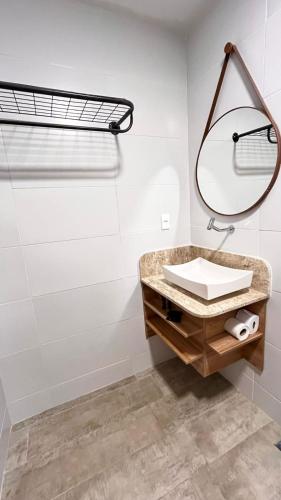 a bathroom with a sink and a mirror at Casarão Suítes Maragogi in Maragogi