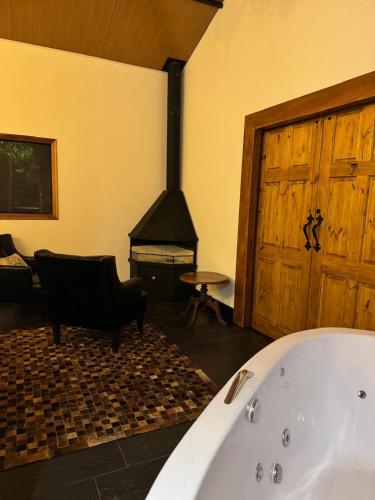 a bath tub in a room with a fireplace at Green Flowers Farm in Córrego do Bom Jesus