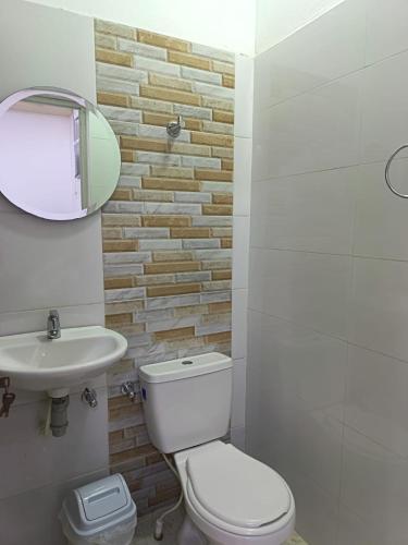 une salle de bain avec toilettes, lavabo et miroir dans l'établissement HOTEL dROHI, à Mangue