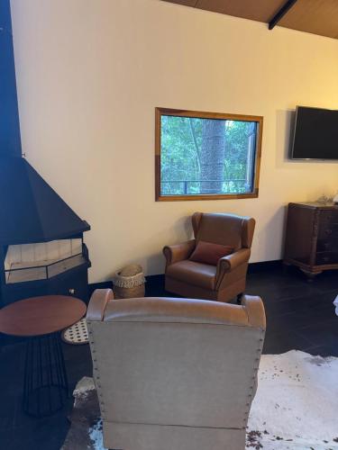 a living room with a couch and a chair at Green Flowers Farm in Córrego do Bom Jesus