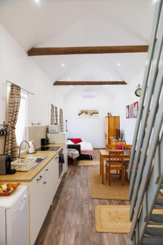 a kitchen and living room with a bed in the background at Forrás Vendégház in Mórahalom