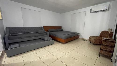 a living room with two beds and a couch at Casa Campo Alegre in Bayamon