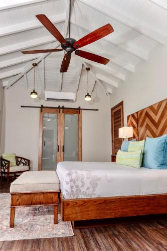 a bedroom with a bed with a ceiling fan at Hammock Cove Antigua - All Inclusive - Adults Only in Willikies