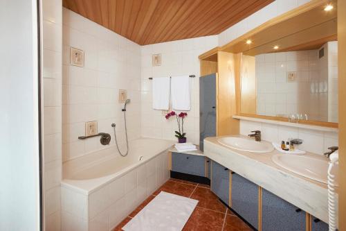 a bathroom with two sinks and a bath tub at Wohlfühlappartements Bayer in Bad Schallerbach