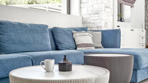 a living room with a blue couch and a coffee table at Alessandra Luxury Villas with Private Pools and Jacuzzi in Kriopigi