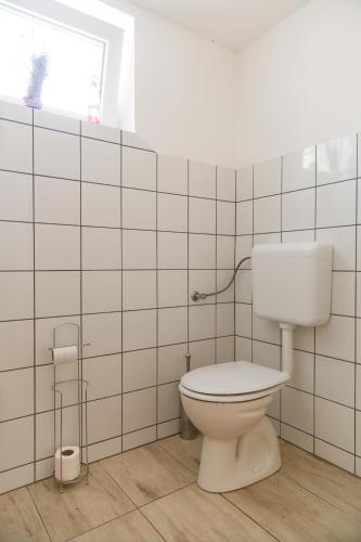 a bathroom with a white toilet and a window at Forrás Vendégház in Mórahalom