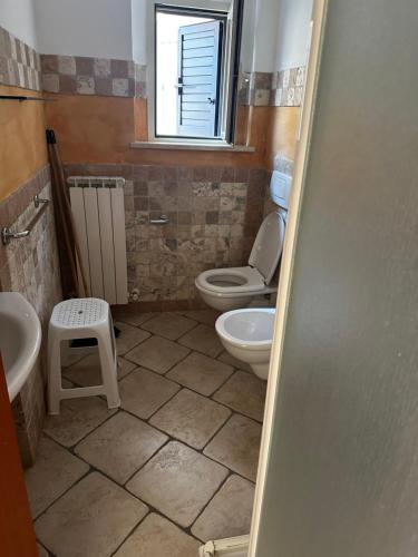 a bathroom with two toilets and a sink and a window at La Piazzetta in Tortoreto Lido