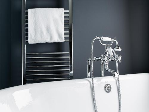 a bath tub in a bathroom with a towel at Grand Ferdinand Vienna – Your Hotel In The City Center in Vienna