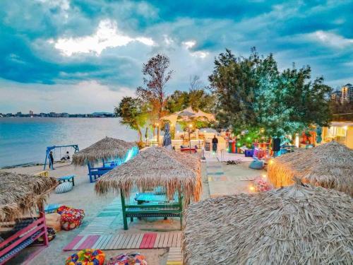 a beach with straw umbrellas and a playground at Sorrento E 4 4 Sveti Vlas in Sveti Vlas