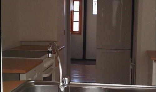 a kitchen with a sink and a refrigerator at Österlens Pärla in Borrby