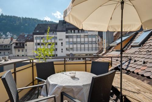 un tavolo e sedie con un ombrellone su un balcone di Ferienwohnung Reinhardt a Triberg