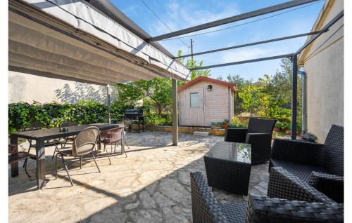 a patio with a table and chairs and a grill at 2 Bedroom Nice Home In Brodarica in Brodarica