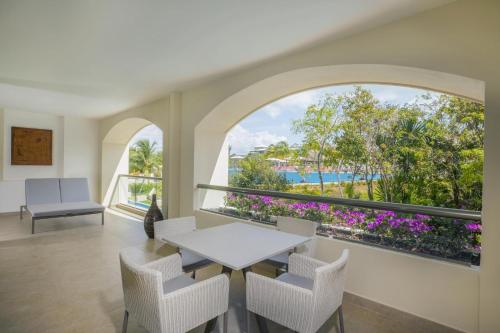 a dining room with a table and chairs and a large window at Moon Palace The Grand Cancun All Inclusive in Cancún