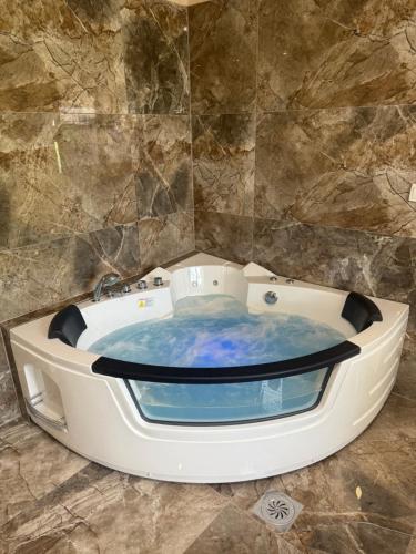 a jacuzzi tub in a room with a stone wall at Place to Be - Modern Jacuzzi House in Vozdovac in Belgrade