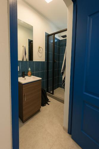 a bathroom with a sink and a blue door at The Duck Dive El Tunco in Tamanique