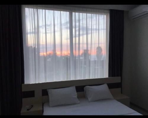 a bed with two pillows in front of a window at Wonderland in Chakvi