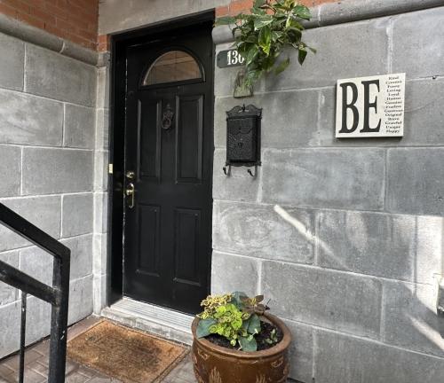 a black door on a stone building with a potted plant at A Gem Downtown Montreal in Montréal