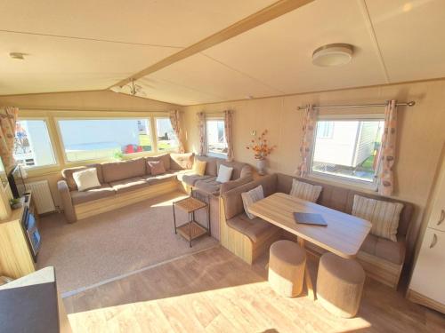 a living room with a couch and a table at Whitstable Trieste - 3 Bedroom, sleeps 8 Pet friendly, family friendly in Seasalter