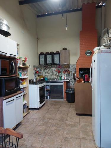 a kitchen with white appliances and a brick wall at Flat Aconchego in Porto Velho