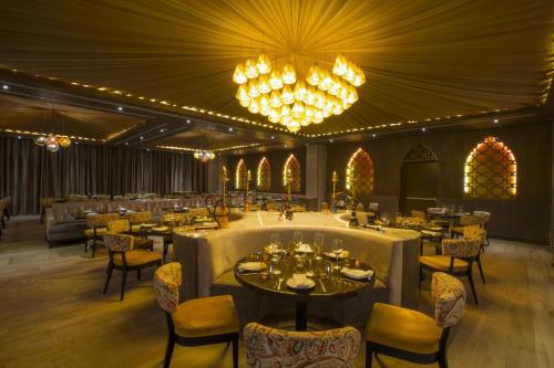 a dining room with tables and chairs and chandeliers at Moon Palace The Grand Cancun All Inclusive in Cancún
