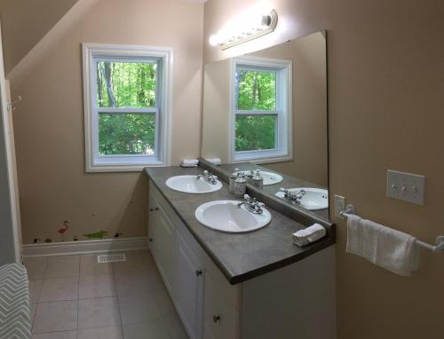 a bathroom with two sinks and two windows at Wares Muskoka Lakes Estate in Gravenhurst