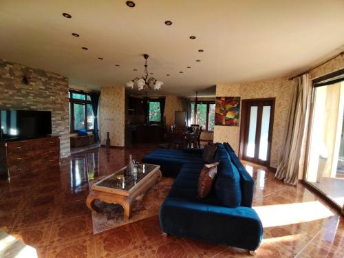 a living room with a blue couch and a table at Villa Flower Deluxe II in Dunajská Streda