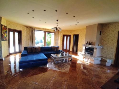 a living room with a blue couch and a fireplace at Villa Flower Deluxe II in Dunajská Streda