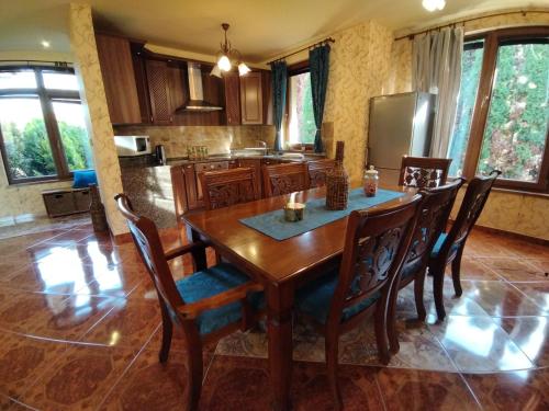 a kitchen with a wooden table and chairs at Villa Flower Deluxe II in Dunajská Streda