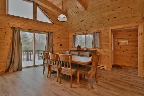 a dining room with a table and chairs in a cabin at NEW ! Lake front Lookout Log Cabin! Private Lake ! in Leonardsville