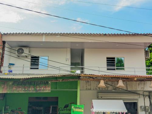 a house with a green and white building at Hostal berpé in Coveñas