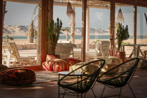 a room with chairs and a view of the beach at Desert Sands Dakhla Lagoon View & Kitesurf Spot in Dakhla