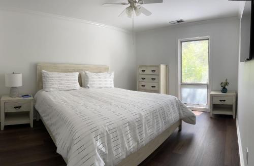 ein weißes Schlafzimmer mit einem weißen Bett und einem Fenster in der Unterkunft 840 Ketch Court at The Sea Pines Resort in Hilton Head Island