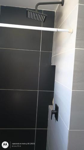 a bathroom with a black and white tiled wall at Casa Farallones a 20 minutos de Cali, Negocios, Familia, Casa tranquila, ideal para trabajos temporales o ejecutivos en la zona, descanso, privacidad, excelente señal wifi in Jamundí