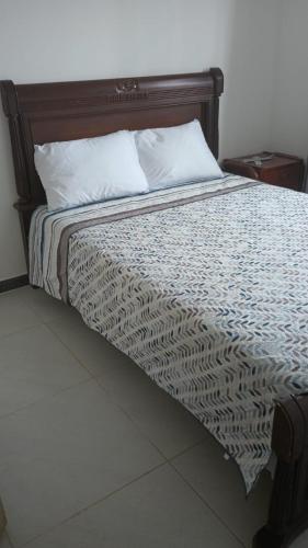 a bed with a wooden headboard in a bedroom at Casa Farallones a 20 minutos de Cali, Negocios, Familia, Casa tranquila, ideal para trabajos temporales o ejecutivos en la zona, descanso, privacidad, excelente señal wifi in Jamundí