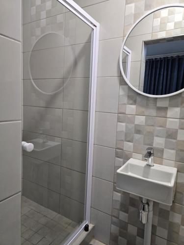 a bathroom with a sink and a mirror at El-Gibbor Residence 1 in Ermelo