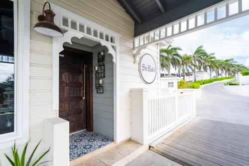 a front door of a beach house with palm trees at Hammock Cove Antigua - All Inclusive - Adults Only in Willikies