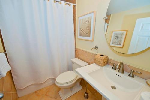 ein Badezimmer mit Toilette, Waschbecken und Spiegel in der Unterkunft 903 Cutter Court at The Sea Pines Resort in Hilton Head Island