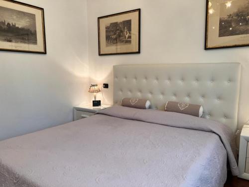 a bedroom with a white bed with two pictures on the wall at Villa Relax&Fly near Malpensa with Pool in Sumirago
