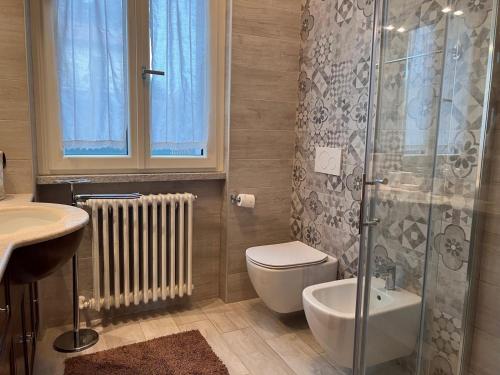 a bathroom with a shower and a toilet and a sink at Villa Relax&Fly near Malpensa with Pool in Sumirago